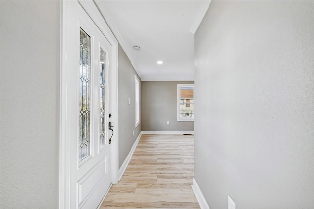 hallway featuring light wood-type flooring and crown molding