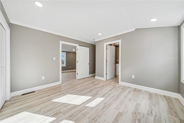 unfurnished bedroom featuring light hardwood / wood-style floors, ornamental molding, and connected bathroom