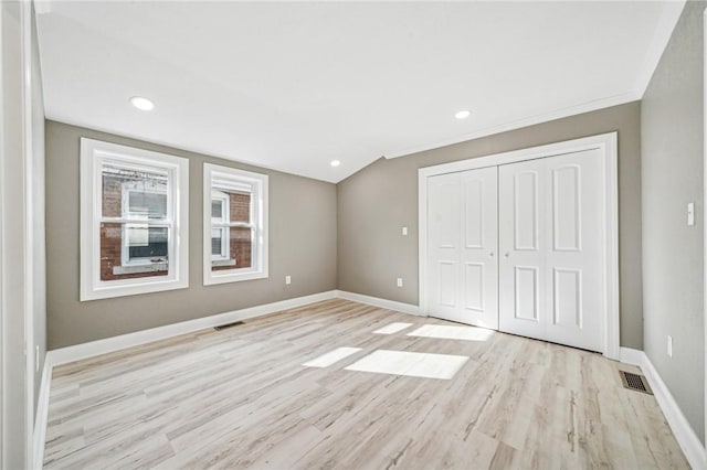 unfurnished bedroom featuring light hardwood / wood-style floors, a closet, and ornamental molding