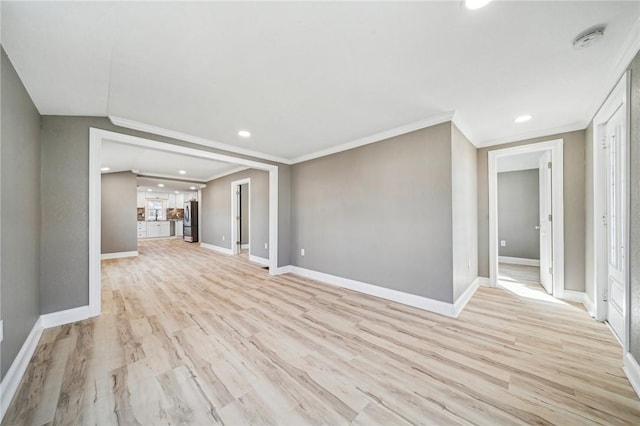 unfurnished living room with lofted ceiling, light wood-type flooring, and ornamental molding