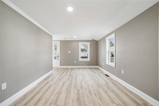 unfurnished room featuring light wood-type flooring and ornamental molding