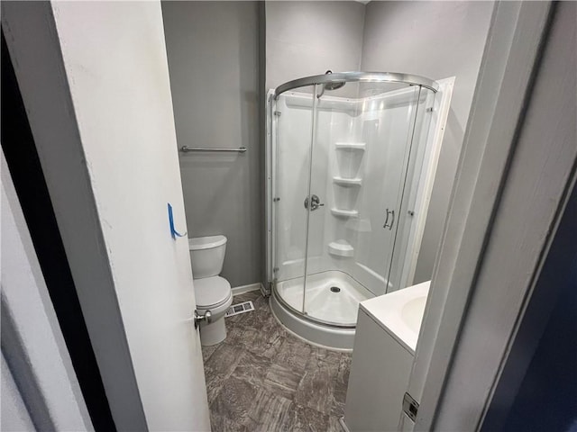 bathroom featuring vanity, toilet, and walk in shower