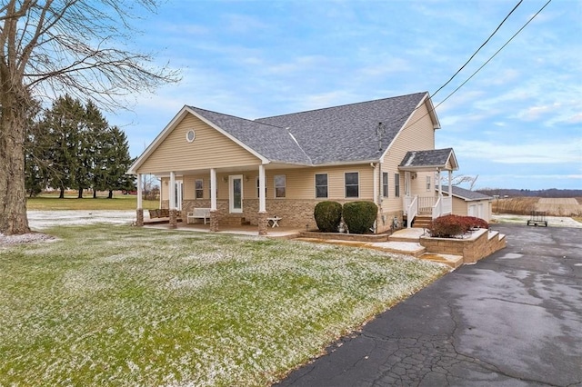 view of front of house with an outdoor structure, a front yard, and a garage