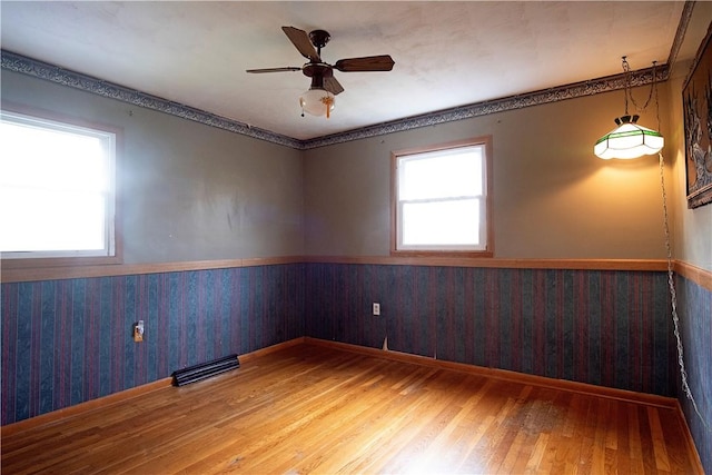 unfurnished room with ceiling fan, wood walls, and hardwood / wood-style flooring