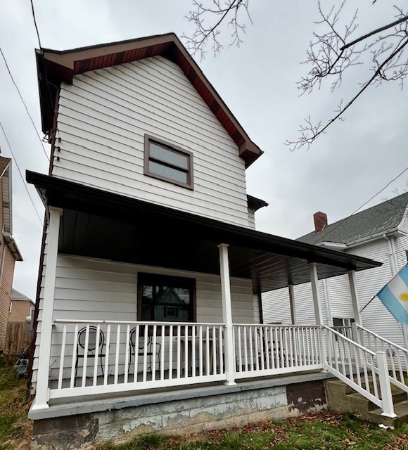 back of house featuring a porch