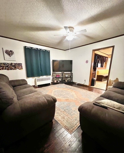 living room featuring radiator, ceiling fan, dark wood-type flooring, and a textured ceiling