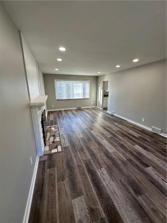 unfurnished living room featuring dark hardwood / wood-style floors and a fireplace