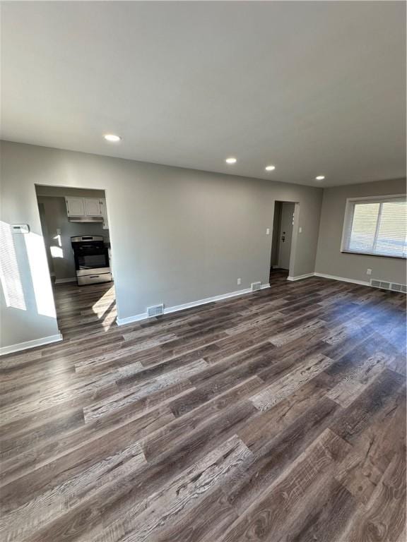 unfurnished living room with dark wood-type flooring