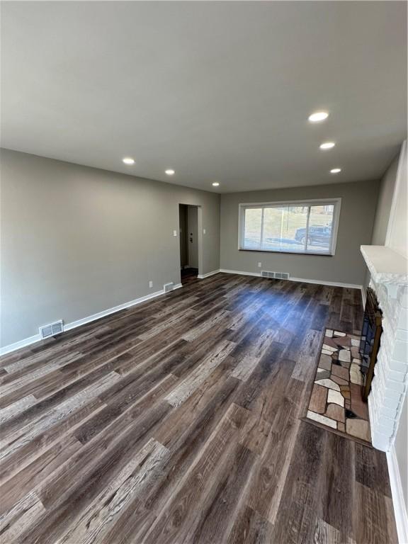 unfurnished living room with dark hardwood / wood-style flooring and a fireplace