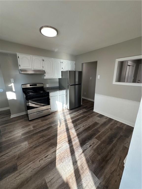 kitchen with dark wood-type flooring, white cabinets, and stainless steel appliances