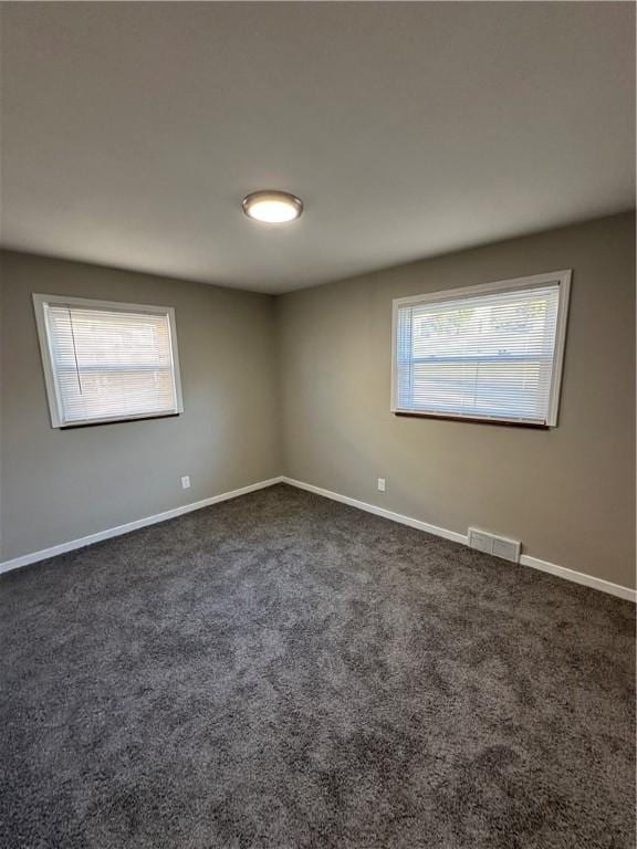 empty room featuring dark colored carpet