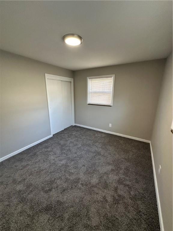 empty room featuring dark carpet