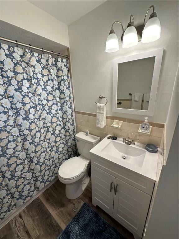 bathroom with hardwood / wood-style flooring, tile walls, toilet, and vanity