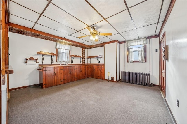 interior space featuring light carpet, radiator heating unit, a wealth of natural light, and ceiling fan