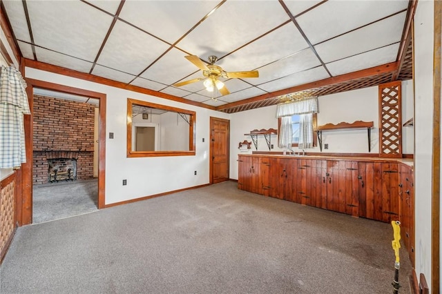 unfurnished living room featuring ceiling fan, light colored carpet, and a fireplace