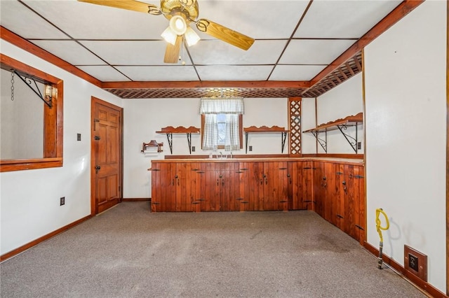 kitchen with a paneled ceiling, light colored carpet, ceiling fan, and sink