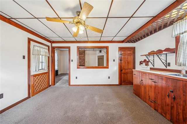 unfurnished living room featuring ceiling fan, sink, and light colored carpet