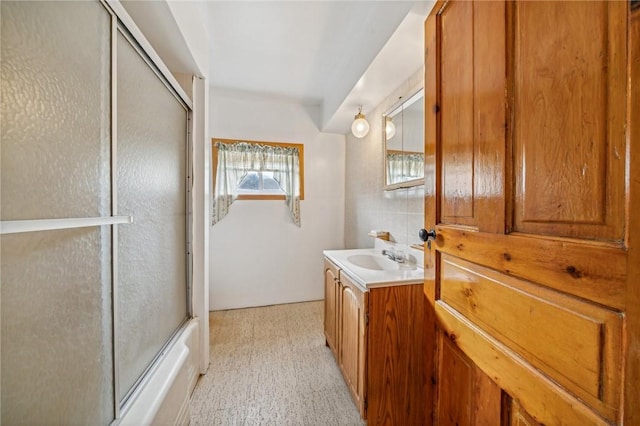 bathroom with backsplash, vanity, and combined bath / shower with glass door