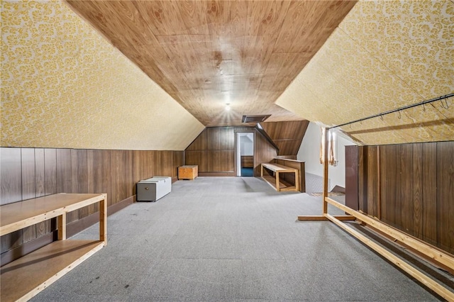 bonus room featuring wood walls and light colored carpet