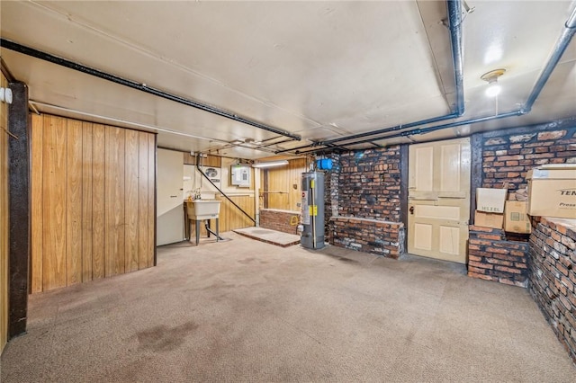 basement with sink, carpet floors, brick wall, and gas water heater