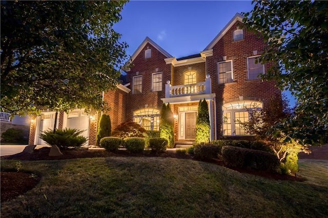 view of front facade featuring a garage, a balcony, and a front yard