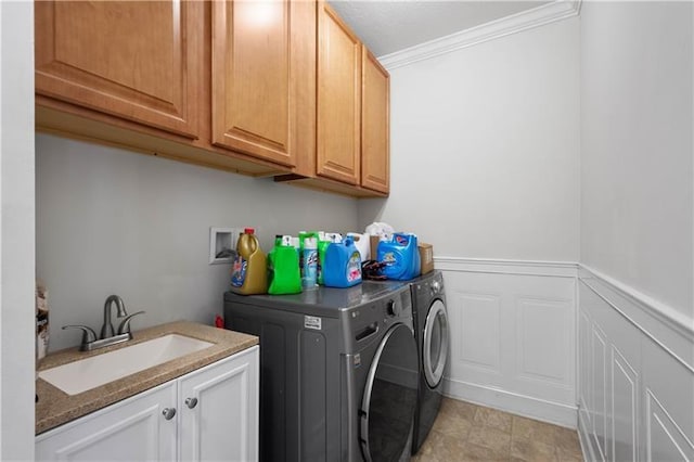 washroom featuring cabinets, washing machine and dryer, crown molding, and sink