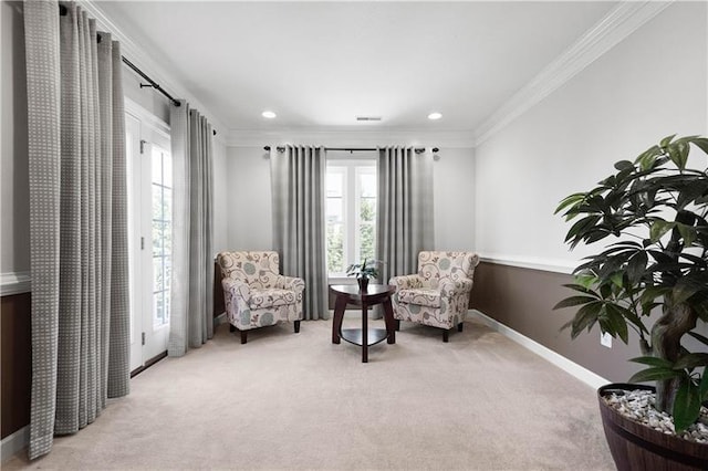 living area with light colored carpet, a healthy amount of sunlight, and ornamental molding