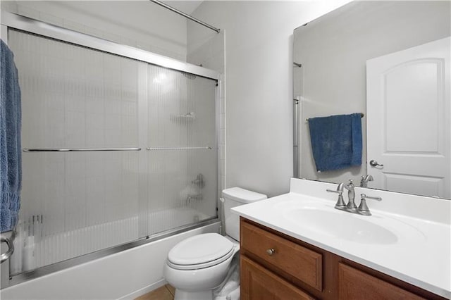 full bathroom featuring toilet, vanity, and combined bath / shower with glass door