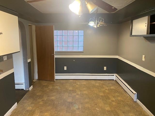 interior space featuring a chandelier and a baseboard heating unit