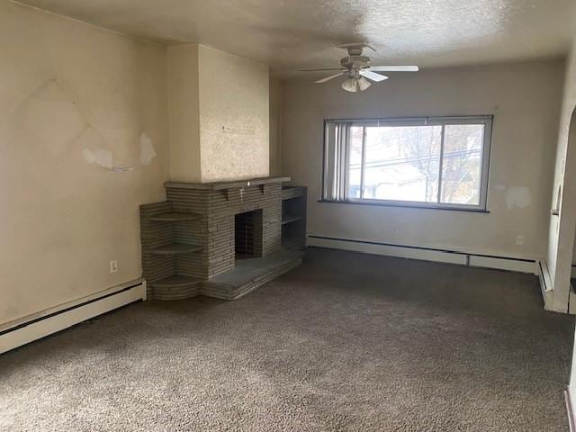 unfurnished living room with carpet flooring, a textured ceiling, ceiling fan, a baseboard radiator, and a fireplace