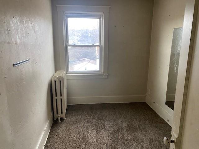 spare room featuring carpet and radiator