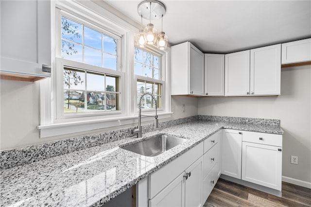 kitchen featuring white cabinets, hanging light fixtures, dark wood-type flooring, and sink