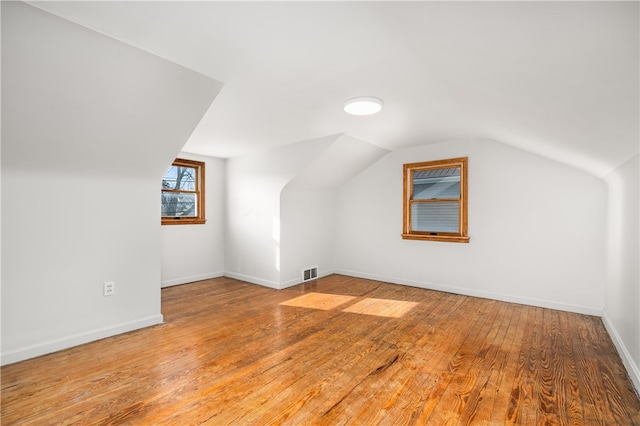 bonus room with lofted ceiling and wood-type flooring