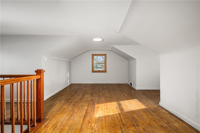 bonus room with wood-type flooring and vaulted ceiling