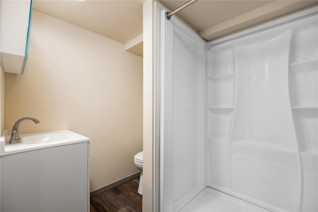 bathroom with vanity, toilet, a shower, and wood-type flooring