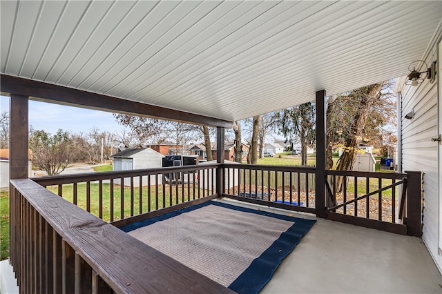 deck with a lawn and a storage shed