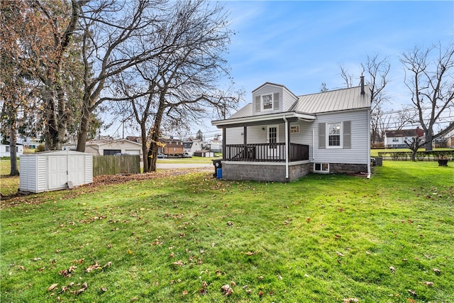 rear view of house featuring a lawn, a shed, and a porch