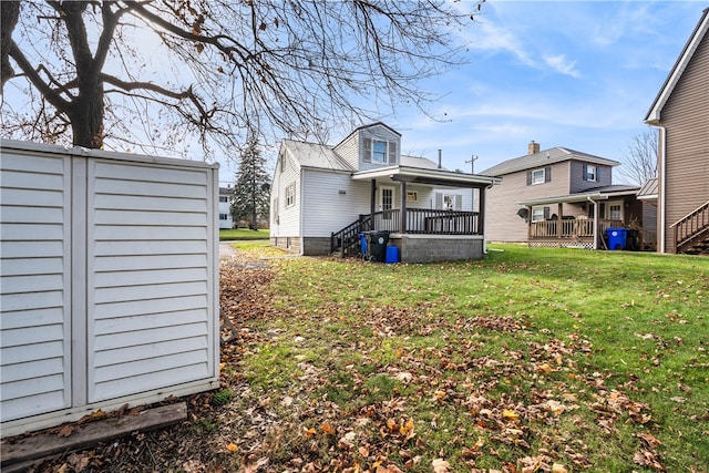 rear view of house with a lawn and a porch