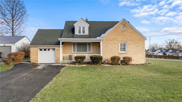 view of front of house with covered porch, a garage, and a front lawn