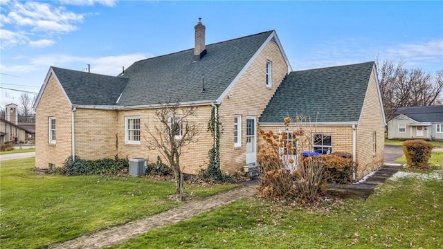 rear view of house featuring a lawn and central air condition unit