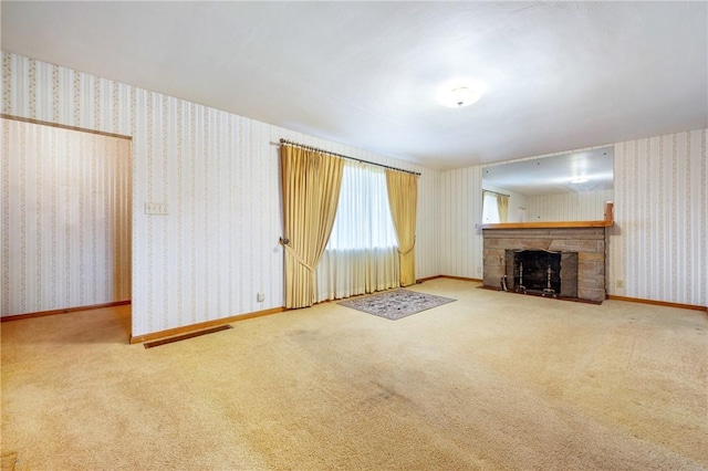 unfurnished living room with carpet and a stone fireplace