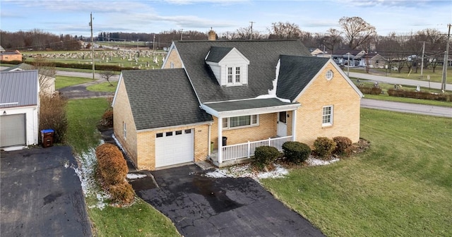 view of front of house featuring a porch, a garage, and a front lawn