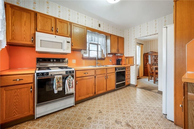 kitchen featuring white appliances and sink