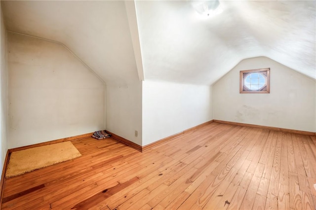 additional living space featuring light hardwood / wood-style floors and vaulted ceiling