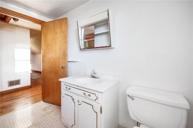 bathroom with hardwood / wood-style flooring, vanity, and toilet