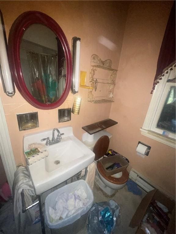 bathroom with a shower with curtain, sink, a baseboard radiator, and toilet