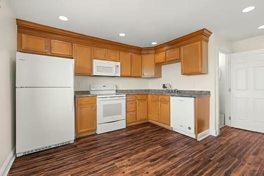 kitchen with dark hardwood / wood-style floors and white appliances