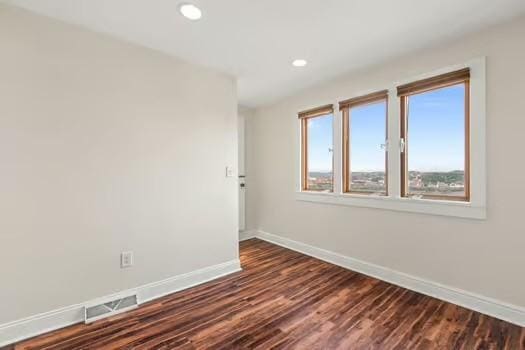 unfurnished room with dark wood-type flooring