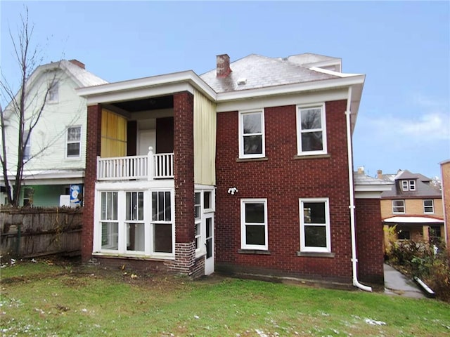 rear view of property with a lawn