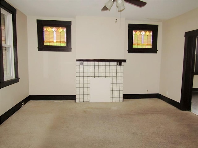 unfurnished living room featuring ceiling fan and light colored carpet